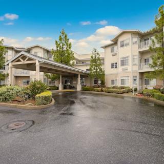 A residential apartment complex with a driveway and landscaped surroundings.