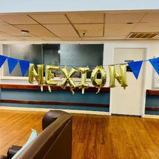 A festive scene showcasing the word 'MEXION' in gold balloons, adorned with blue pennant banners.