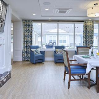 A bright and modern dining area featuring blue chairs, large windows, and a cozy ambiance.