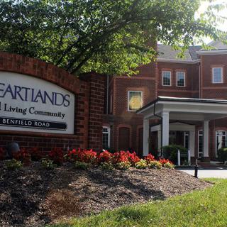 Entrance of Heartlands Assisted Living Community with a well-maintained garden and prominent signage.