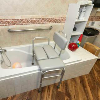 An accessible bathroom setup with a shower chair placed over the bathtub for safety and convenience.
