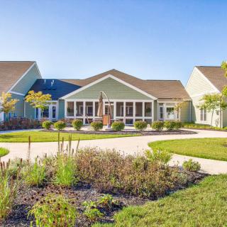 A residential building with well-maintained landscaping under a clear blue sky.