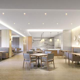 A modern restaurant interior with neatly arranged tables and chairs under soft lighting.