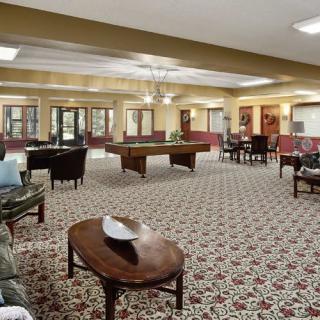 A spacious lounge with a pool table and various seating areas.