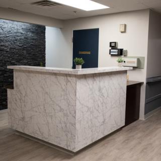A modern reception desk made of marble in an office lobby.