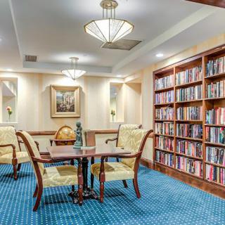 A cozy library reading area with bookshelves, a table, and chairs.