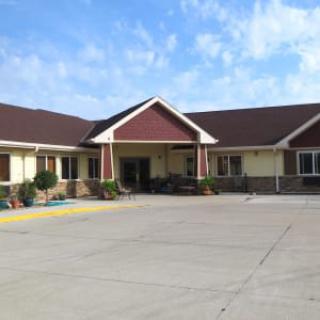 A single-story building with a front entrance, set against a blue sky.