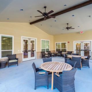 A spacious patio with outdoor seating and ceiling fans.