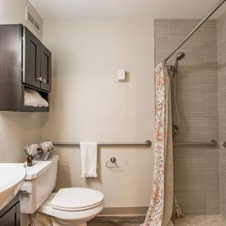A clean and modern bathroom with a shower and cabinet.