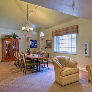 A cozy dining room with a large table and chairs, featuring a window and a cabinet against the wall.