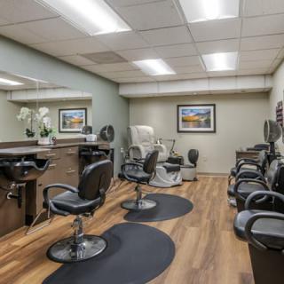 A modern hair salon interior with several styling stations and mirrors.