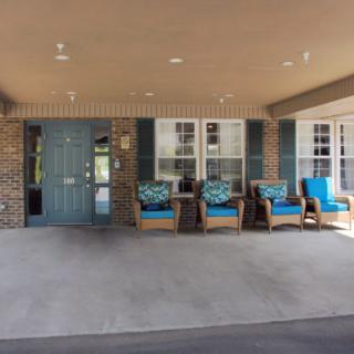 A cozy porch area with seating and a blue door.