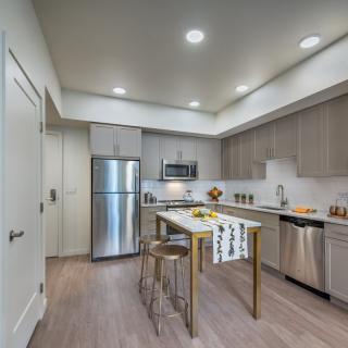 A modern kitchen with stainless steel appliances and a central island.