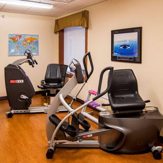 A small fitness room with exercise equipment including stationary bikes and ellipticals.