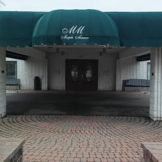 A welcoming entrance with a green awning and cobblestone pathway.