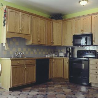 A modern kitchen with wooden cabinets and black appliances.