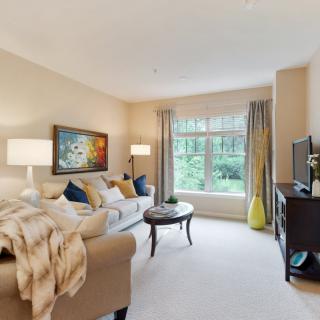 A cozy living room with a comfortable sofa, decorative artwork, and a large window.
