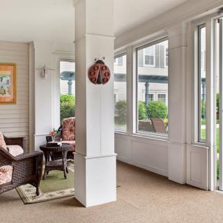 A cozy sunroom with comfortable seating and large windows allowing abundant natural light.