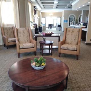 A cozy lobby area featuring comfortable chairs and a center table with decorative plants.
