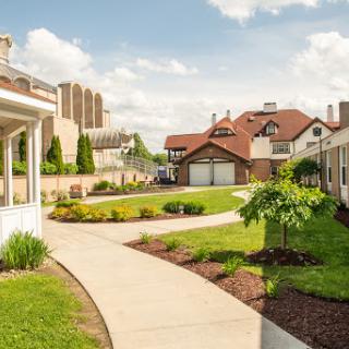 A peaceful residential area featuring well-maintained gardens and charming houses under a clear blue sky.