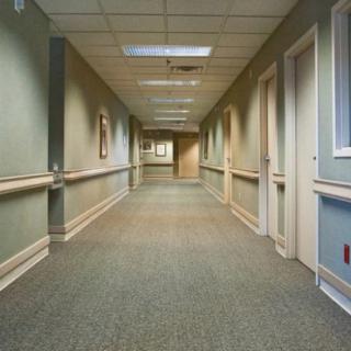 A long, empty hallway with multiple doors on either side.