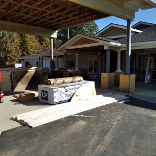 A residential home under renovation with construction materials in the driveway.