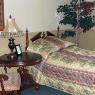 A cozy bedroom with a single bed, side table, and decorative elements.