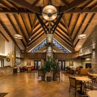 A spacious and elegantly designed lobby with wooden beams and modern lighting.