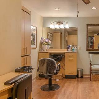 A cozy and well-organized hair salon interior with chairs, mirrors, and warm lighting.