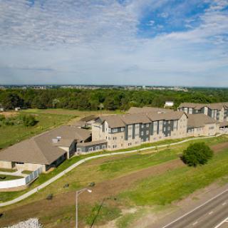 Aerial view of a modern apartment complex surrounded by greenery.