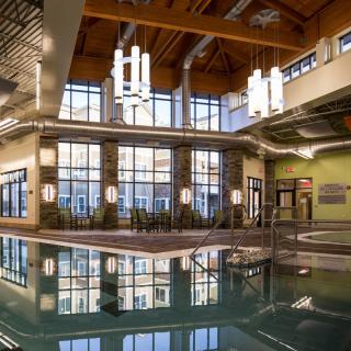 A spacious indoor pool area with modern architecture and large windows providing natural light.