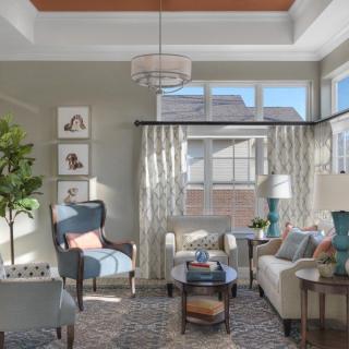 A cozy and elegantly designed living room with ample natural light, featuring modern furniture and decor.