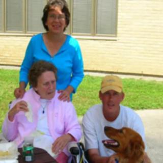 A group of people with a dog enjoying time outdoors together.