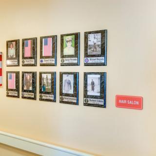 A wall display featuring framed photographs and artwork in a gallery setting.