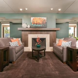 A modern living room with a central fireplace, flanked by two sofas and a coffee table.