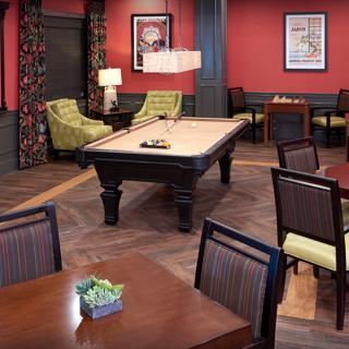 A stylish game room featuring a pool table and comfortable seating.