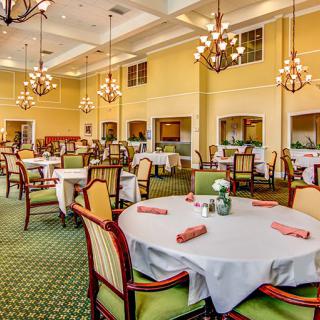 Elegant dining room with round tables and chandeliers.