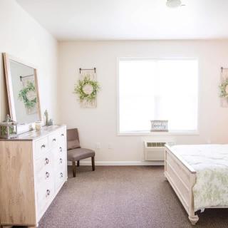 A minimalist bedroom with natural light and simple decor.