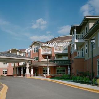 A modern senior living facility with multiple stories and a welcoming entrance.