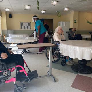A glimpse into a nursing home where elderly residents are interacting with staff.
