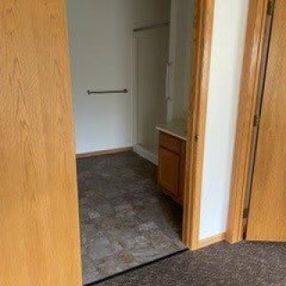 A view of a bathroom through an open doorway, showcasing the sink and tiled flooring.