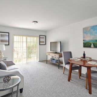 A cozy living room with modern decor, featuring a sofa, dining table, and TV.