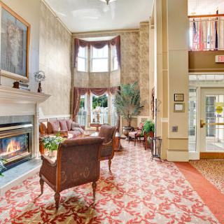 A cozy and elegant lobby featuring a fireplace, inviting seating, and warm decor.