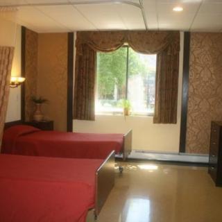 A hospital room with two beds and a window with curtains.