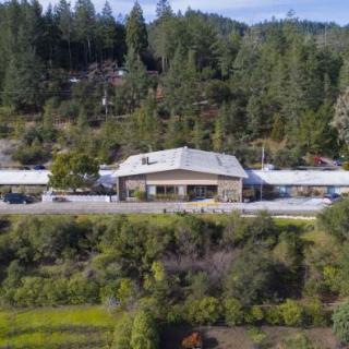 A building nestled in a forested landscape.