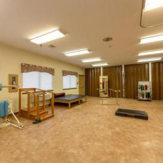A spacious physical therapy room equipped with various exercise tools for rehabilitation.