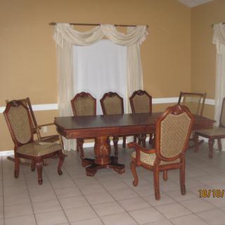 A classic dining room setup with a wooden table and upholstered chairs.
