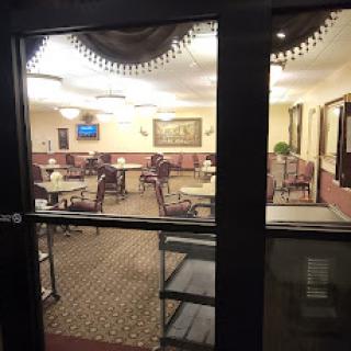 A view of a cozy dining area through glass doors, featuring well-arranged tables and chairs.