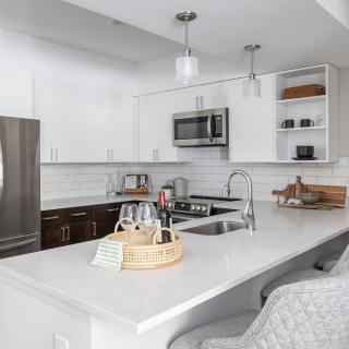 A modern kitchen with white cabinets and stainless steel appliances.