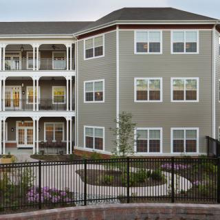 A modern apartment building with multiple balconies and well-maintained landscaping.